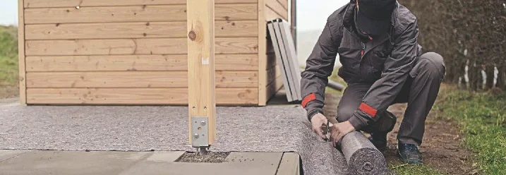 Person schneidet ein Vlies mit einer Schere.